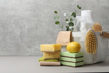 Eco-friendly cleaning products, supplies and eucalyptus branches on grey table, space for text