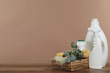 Eco-friendly cleaning products, supplies and eucalyptus branches on wooden table, space for text
