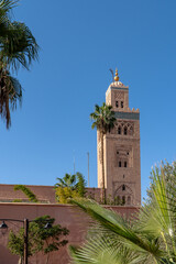 Obraz premium Koutoubia Mosque - largest mosque in Marrakesh, Morocco, Africa. A majestic building (tower) with a golden top. Palma trees on first plan.