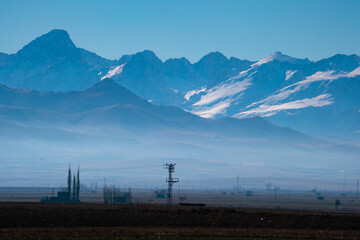 Snow-covered majestic mountain with a village at its base. Stunning winter scenery with a mountain and village. Selective focus.