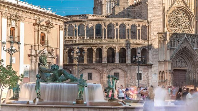 Timelapse of Plaza de la Virgen with the iconic Turia Fountain in Valencia, Spain. The Neptune statue represents the Turia River and its canals. People strolling around the square with moving shadow