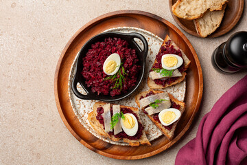 Top view of Scandinavian open sandwich Smorrebrod with pickled herring, Beet or beetroot, Caviar  and boiled quail egg.