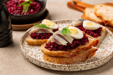 Smorrebrod, scandinavian open sandwich with pickled herring, Beet or beetroot, Caviar  and boiled quail egg, dill.
