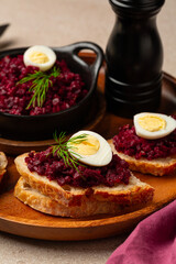 Beet or beetroot Caviar sandwich with boiled quail egg, bread and roasted vegetable toast. Healthy snack. Verttical image.