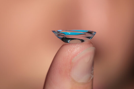 Close-up of a contact lens on a woman's finger