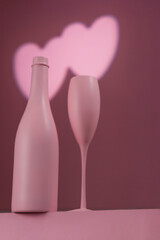 Copa y botella rosa en fondo rosa con luz de corazón