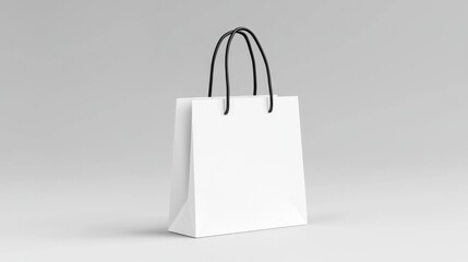 A white paper shopping bag with black handles is isolated against a plain white background, showcasing a minimalist design.