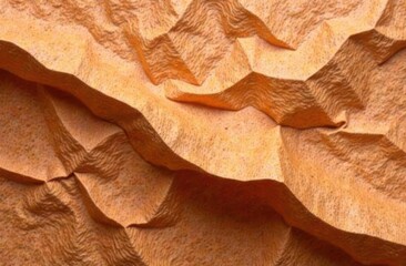 textured orange fabric with detailed folds and shadows creating pattern. warm color palette....