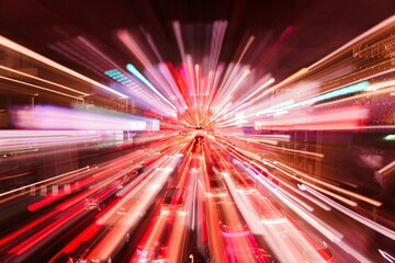 Vibrant light trails depict the chaos of rush hour traffic in a busy urban area