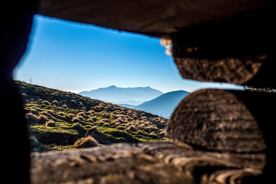 Mountainous Landscape Framed by Wooden Logs with Jagged Ridge