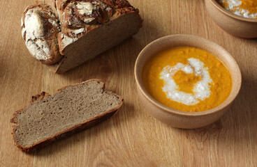 Pumpkin soup in bowl with bread