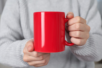 Woman with red ceramic cup, closeup. Mockup for design