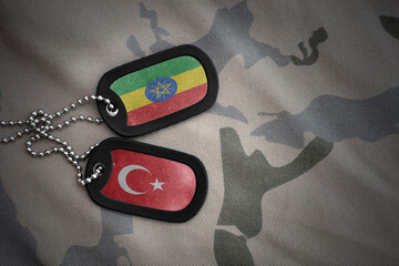 vintage army blank, dog tag with flag of ethiopia and turkey on the khaki texture background....