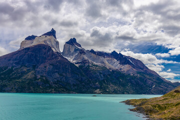 Obraz premium Torres del Paine national park in Patagonia, Chile. Beautiful landscape of Torres del Paine peaks, Los Cuernos and Paine Grande mountain summit in nasty weather with some dark clouds before the storm.