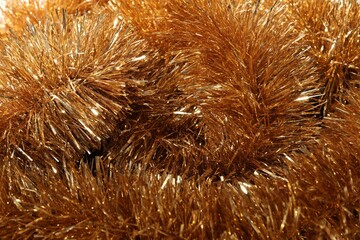 Shiny golden tinsel as background, closeup view