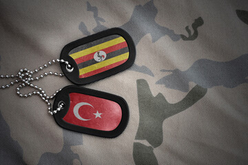 vintage army blank, dog tag with flag of uganda and turkey on the khaki texture background....