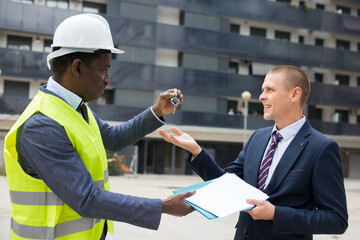 Man reciveing keys to new apartment from engineer