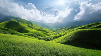 Obraz premium Lush green hills and valleys bathed in sunlight under a partly cloudy sky.