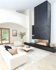 Modern living room with large fireplace, high ceiling, and outdoor view; ideal for interior design or real estate