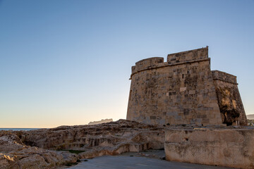 view of Castell de Moraira from a low angle as the sun begins to set on a winters day