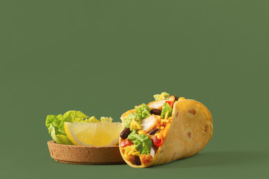 Delicious and colorful taco with fresh ingredients on green