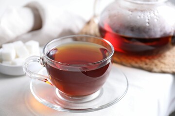 Refreshing black tea in cup on light table, closeup