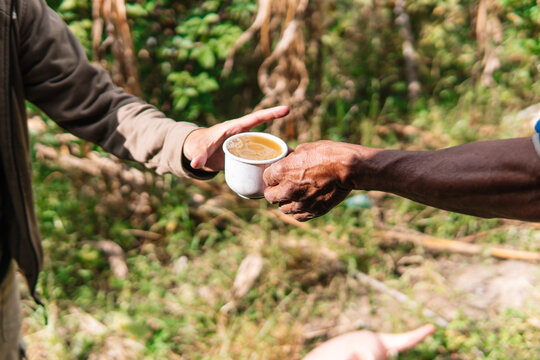 Hands Sharing a Cup of Guarapo in Colombian Countryside