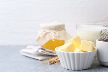 Fresh butter, honey and milk on light grey table, closeup. Space for text