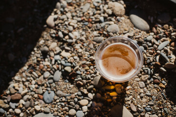 A glass of cold beer stands on the beach, capturing the essence of a relaxing, sunny day at the beach, an all-inclusive vacation
