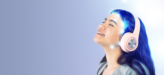 A young woman enjoys music while using advanced face recognition technology. Her expression shows...