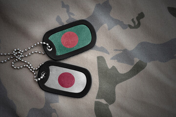vintage army blank, dog tag with flag of bangladesh and japan on the khaki texture background....