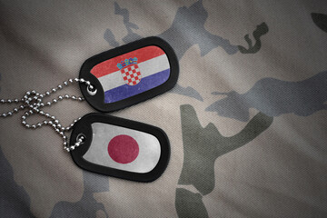 vintage army blank, dog tag with flag of croatia and japan on the khaki texture background....