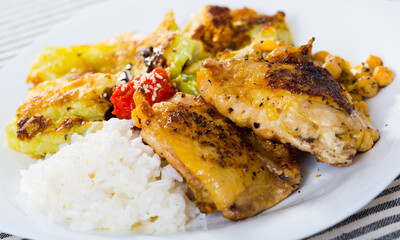 Delicious roasted chicken thighs with garnish of chickpeas and rice, battered cabbage, two sauces