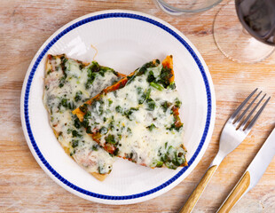 Appetizing pizza with tender greens of spinach and cheese