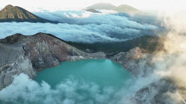 Aerial view Drone shot of fog at Kawah Ijen volcano with turquoise sulfur water lake and sunrise light.Amazing nature landscape view at East Java,Indonesia.Beautiful light Natural landscape background