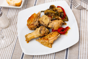 Delicious baked chicken thigh with stewed vegetables on a plate