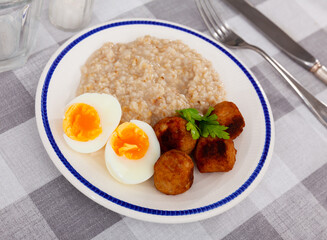 Breakfast with scrumble egg and oatmeal and meatballs