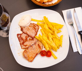Delicious fried beef filet with freshly ground pepper served french fries with white sauce.