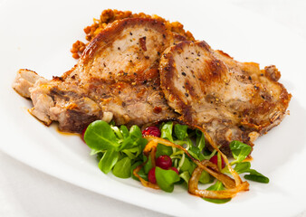 Baked pork shank with lentils garnishing with green corn salad and berries of redcurrant..