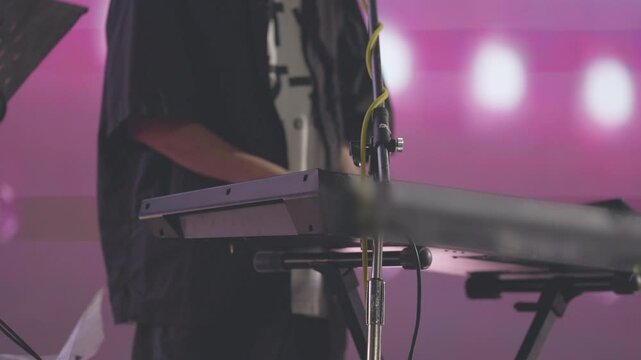 A man is playing a keyboard with a microphone in front of him. Concept of creativity and expression, as the man is likely a musician or performer