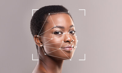 A close-up view of a person’s face is enhanced by facial recognition technology. Geometric lines...