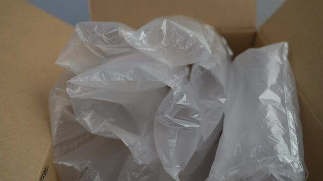 brown paper cardboard box and translucent white plastic bubble wrap