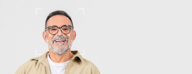 A smiling older man with glasses faces the camera, showcasing advanced facial recognition technology. The background is plain, emphasizing the identification process in a clean, isolated space.