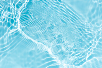 Blue water with ripples on the surface. Defocus blurred transparent blue colored clear calm water surface texture with splashes and bubbles. Water waves with shining pattern texture background.