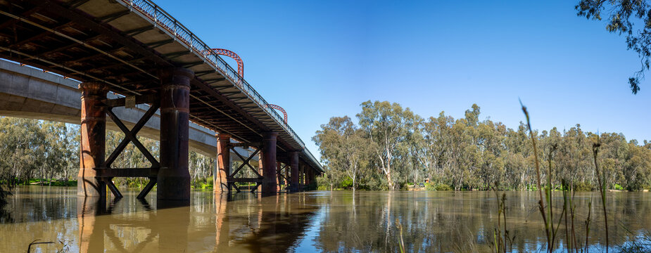 Panoramic view of historic Echuca-moama Road Rail Bridge over calm waters of the Murray River, between the twin towns of Echuca in Victoria and Moama in New South Wales and a heritage local landmark.