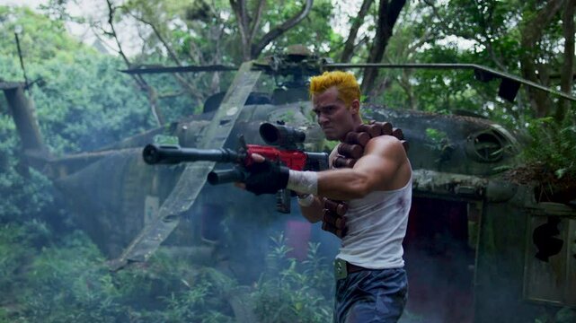 Muscular guy in tank top stumbling out of smoking, crashed helicopter - steady cam shot