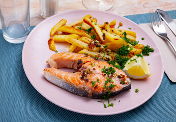Deliciously steak of baked salmon with greens and potatoes