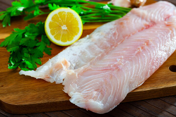 Raw seafood, fresh perch fillet on wooden board