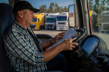 Truck driver looking at paperwork before he goes on the route 