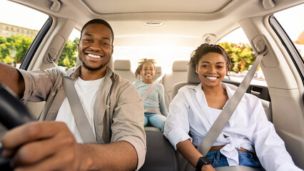 Black Parents And Daughter Posing Riding New Car Smiling To Camera Enjoying Road Trip. Family...